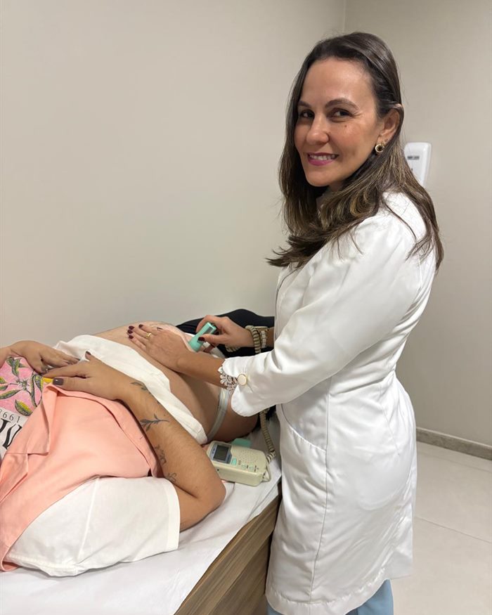 Dra. Luana Figuerêdo em consulta de pré-natal, ouvindo os batimentos do bebê