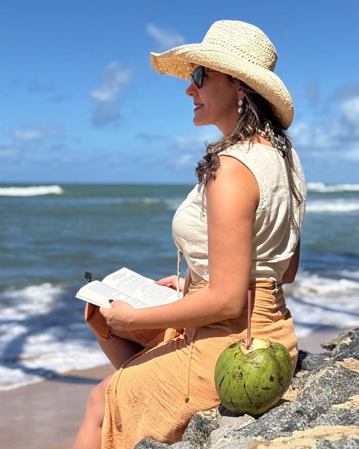 Dra. Luana Figuerêdo lendo na praia